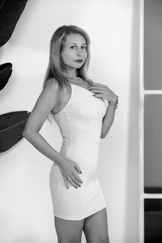 Stylish black and white portrait of a woman in a fitted dress.