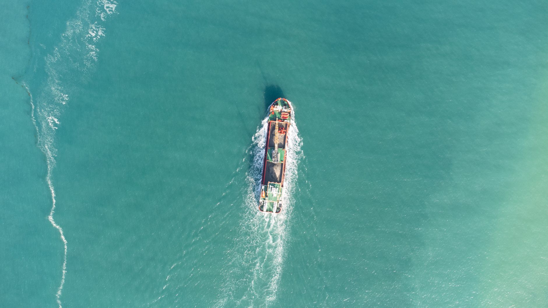 A cargo ship moving through open water, reflecting the commercial traffic that would need proof of safety before returning to the Strait of Hormuz.