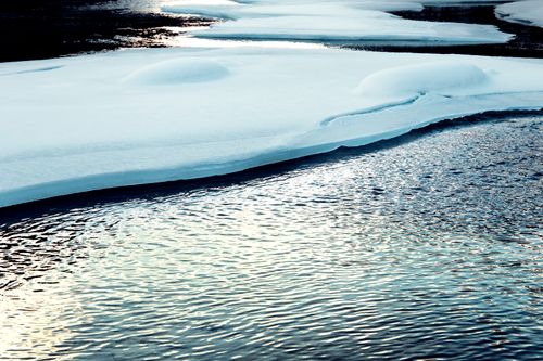 Free Calm winter lake with snowy ice formations reflecting the cold and serene atmosphere. Stock Photo