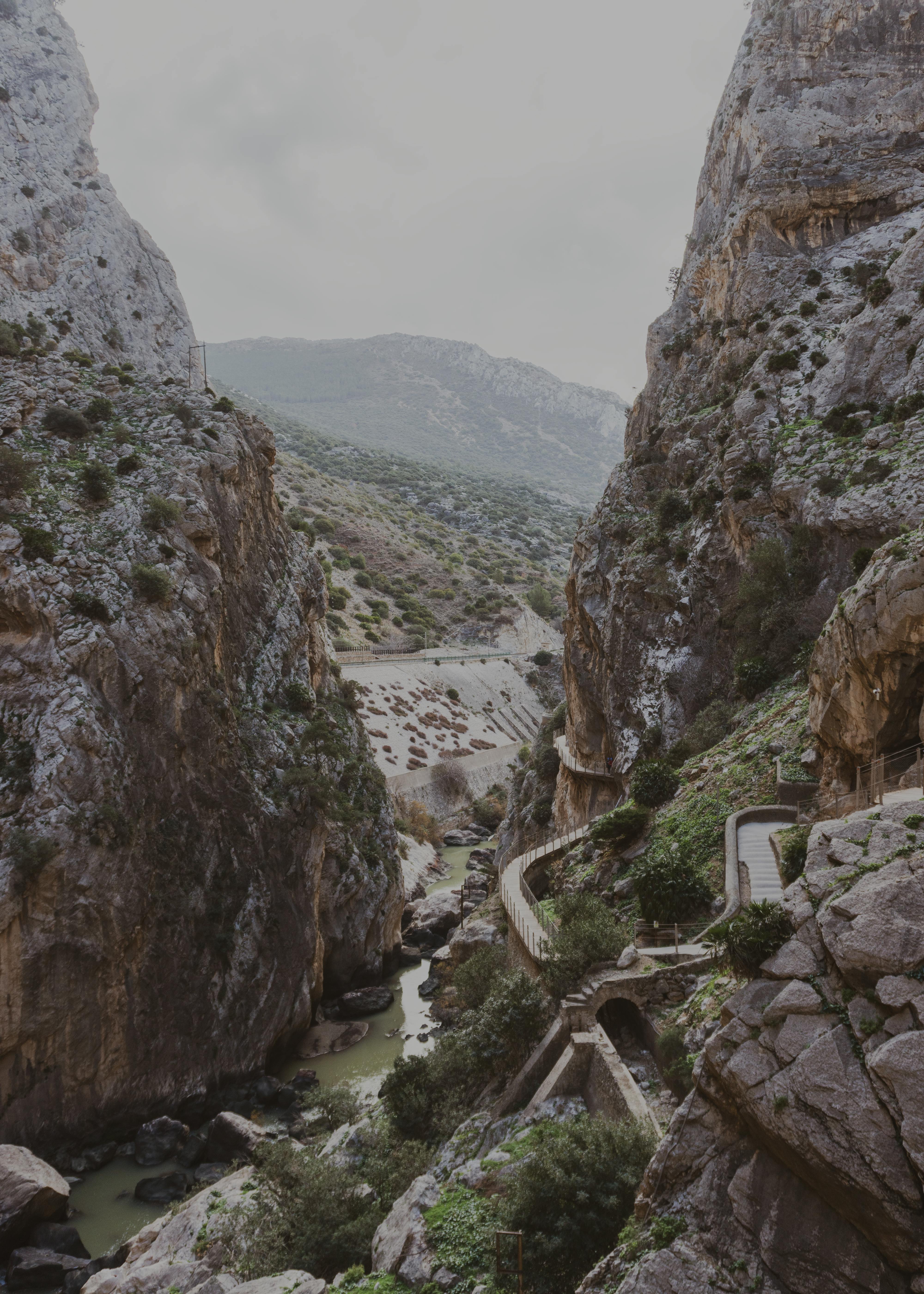 Breathtaking aerial view of El Chorro gorge, Spain, showcasing rugged cliffs and a winding pathway.