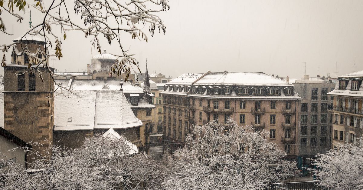 Snow-covered European city street with Christmas lights and winter markets during the holiday season