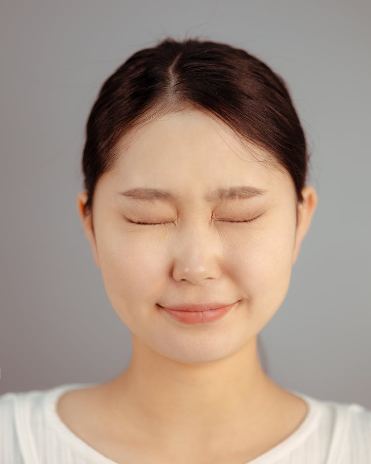 Portrait Of A Young Woman Smiling With Her Eyes Shut 