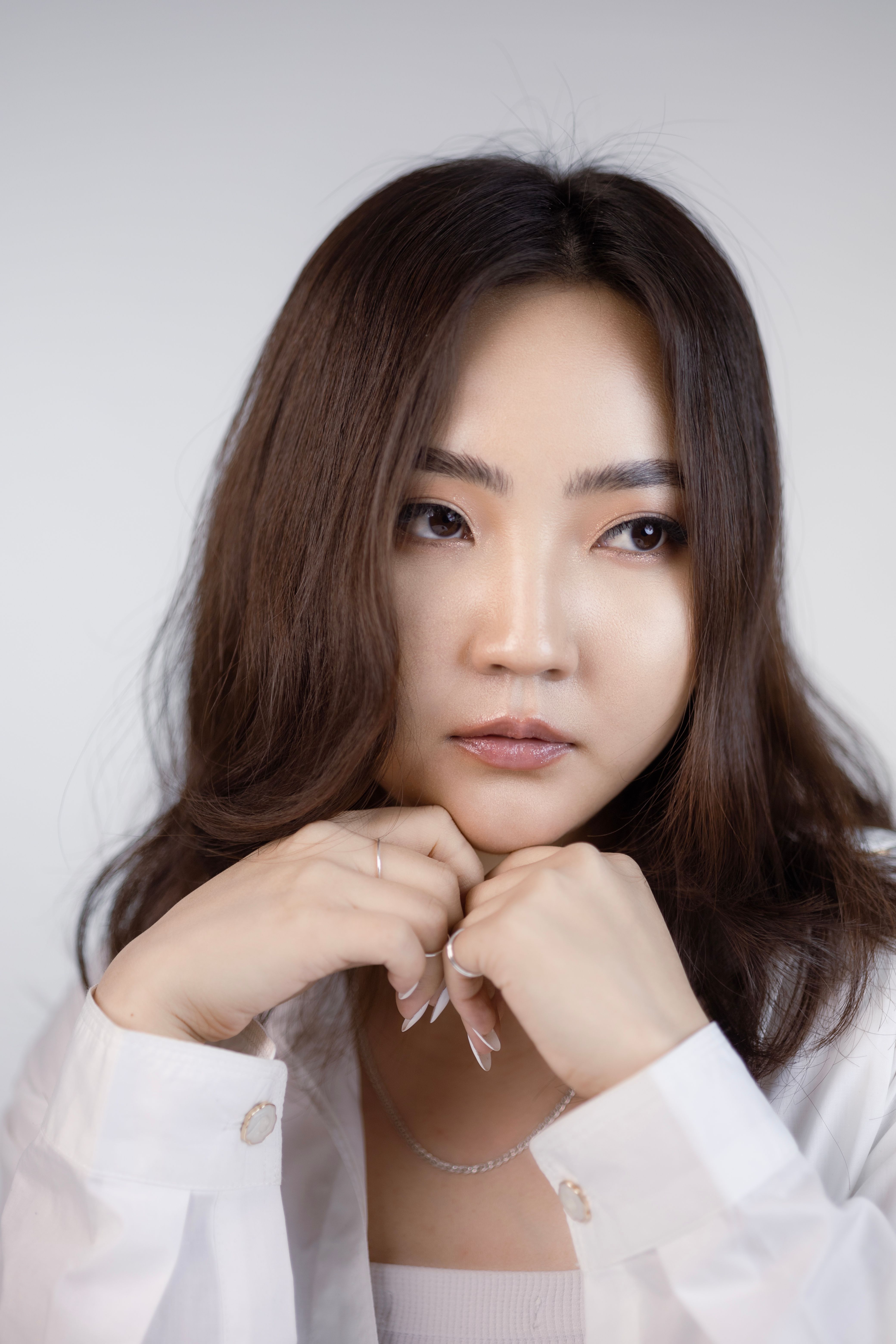 Portrait of a young woman with long hair in a studio setting, showcasing elegance and style.