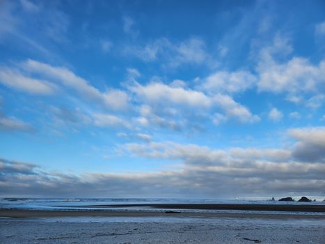 A peaceful coastal beach scene with a vast cloudy sky, perfect for tranquil themes.