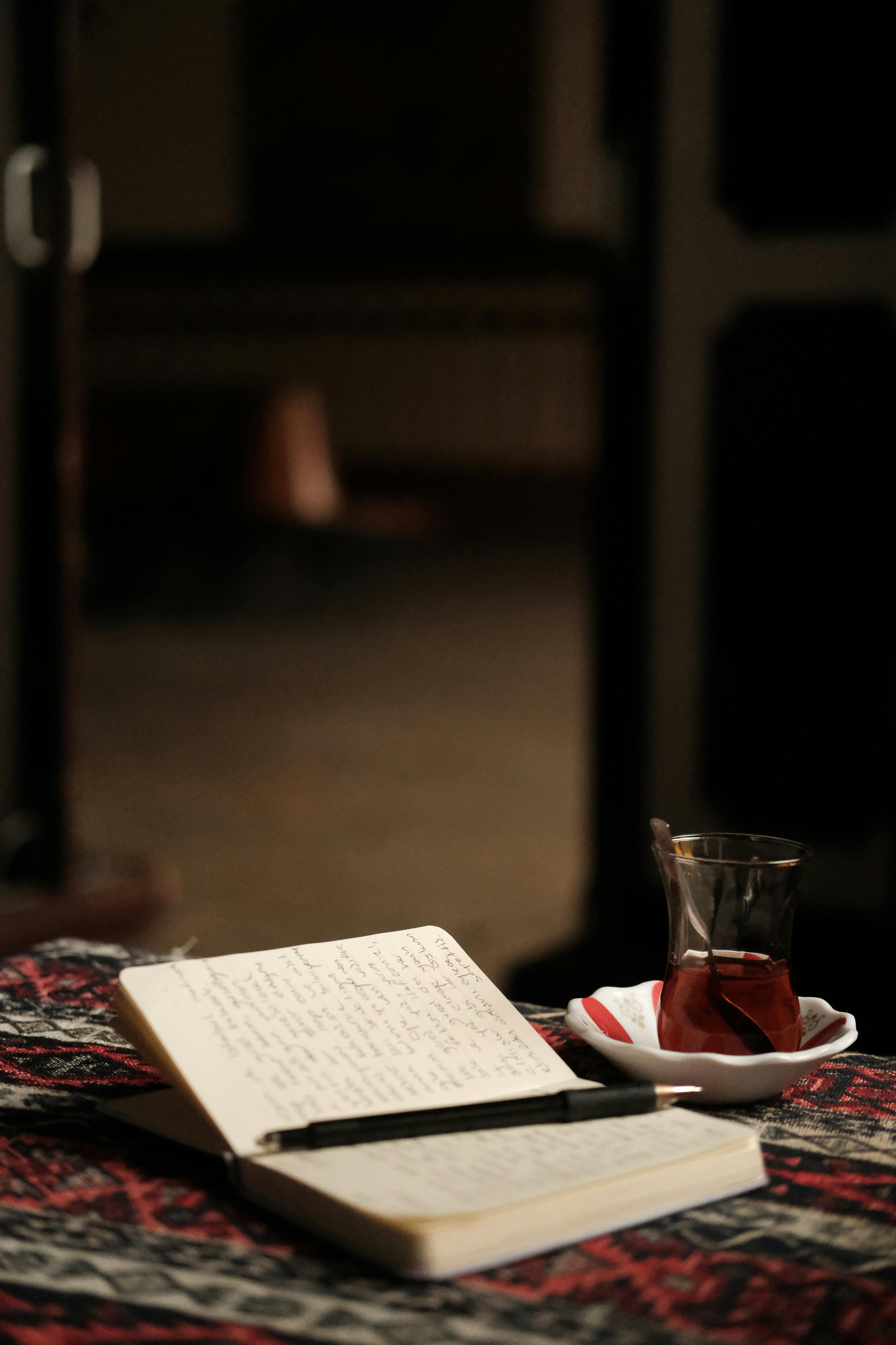 A warm indoor setting with a notebook and traditional Turkish tea. Perfect for reflective moments.