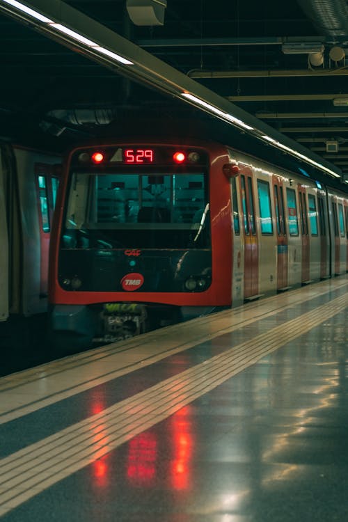 A red train is parked at a station