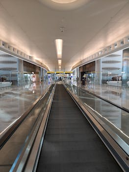 View of a modern Abu Dhabi airport interior featuring moving walkways and sleek architecture.