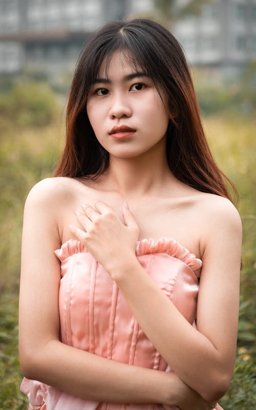 A young woman in a pink dress posing for the camera