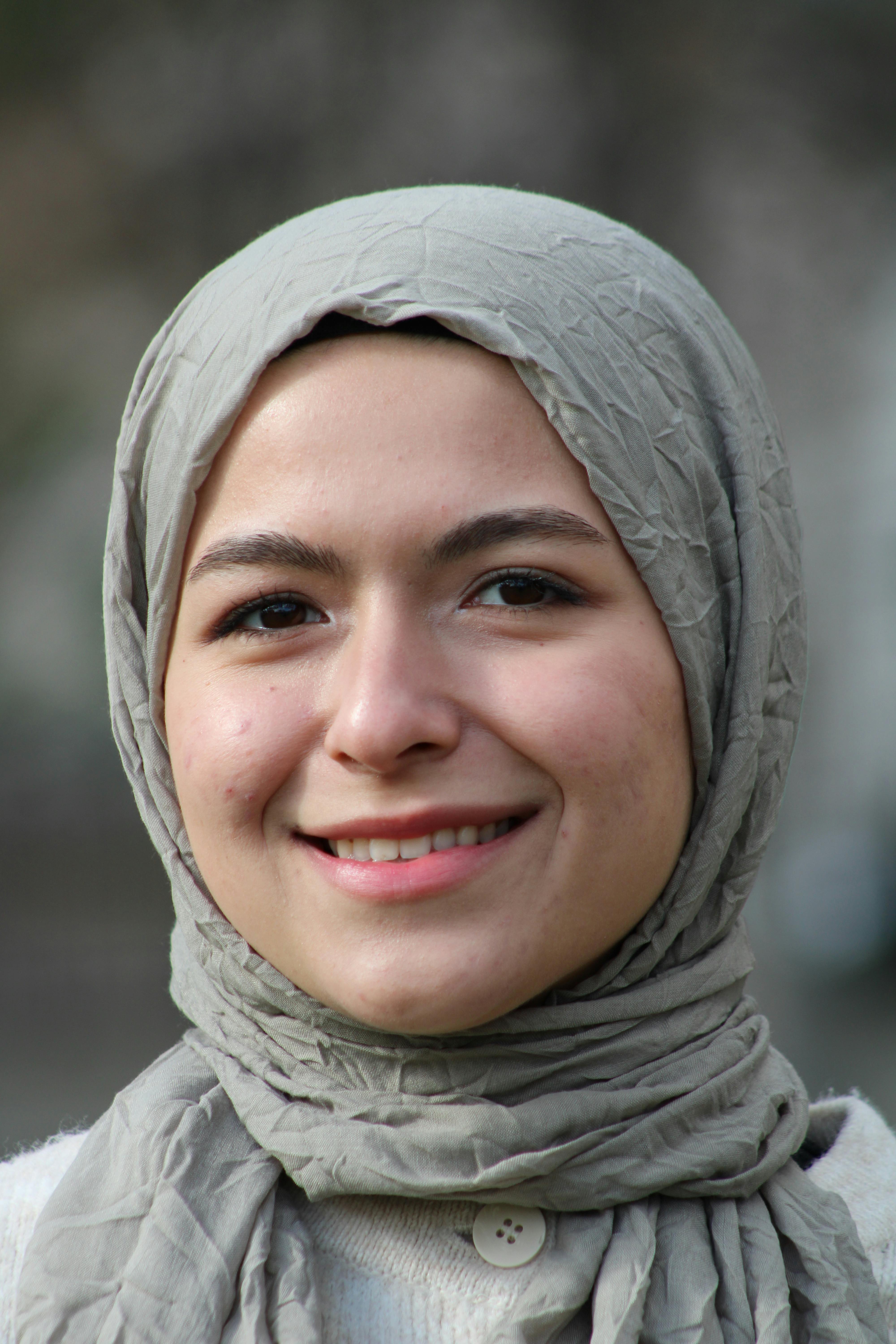Close-up of a smiling woman in a hijab, showcasing warmth and positivity.