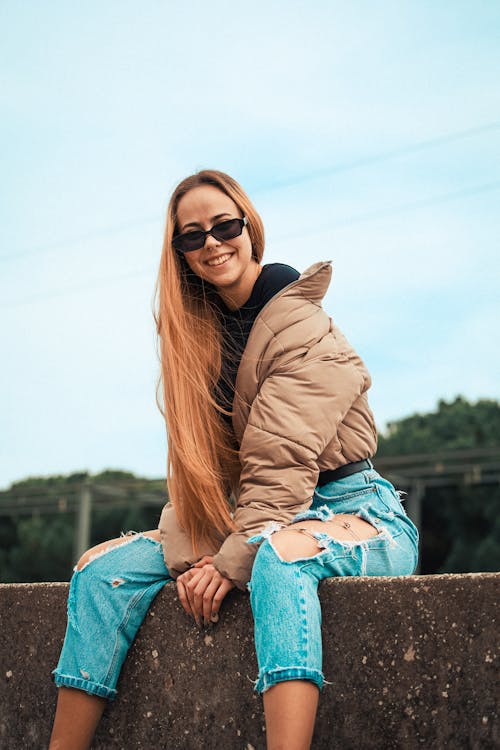 Smiling Blonde Woman in Sunglasses and Jacket