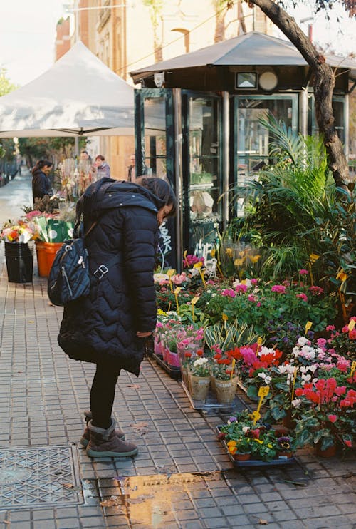 Woman Looking at Flowers at Florist in Town