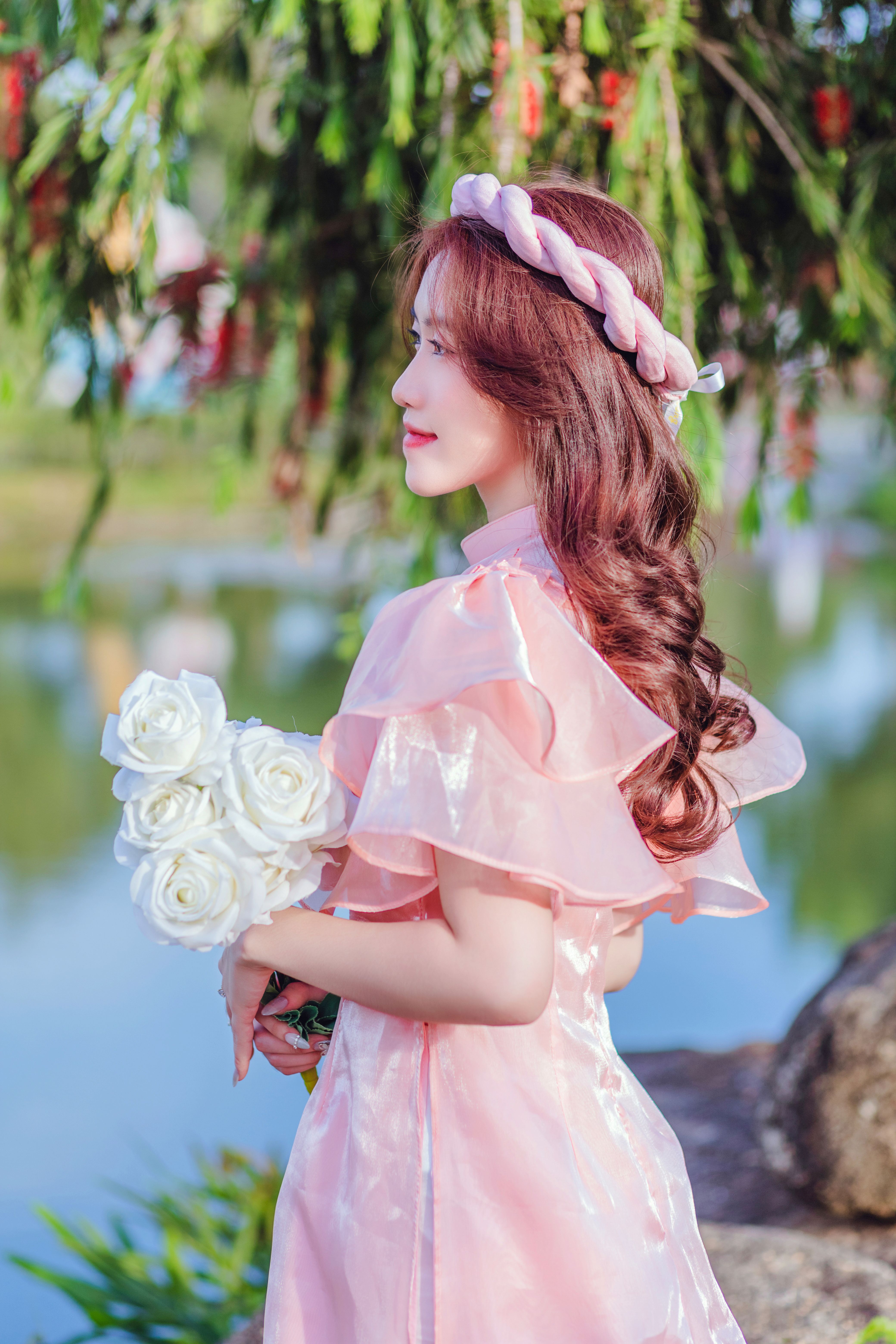 Brunette in Pink Dress Posing with Flowers · Free Stock Photo