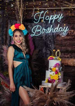 Woman celebrating 40th birthday with colorful flowers and cake in Guatemala.