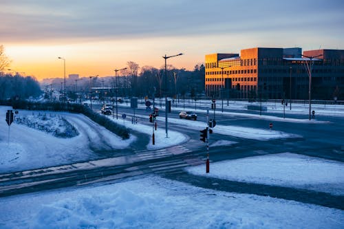 View of Snowy Streets and Buildings in City at Sunset