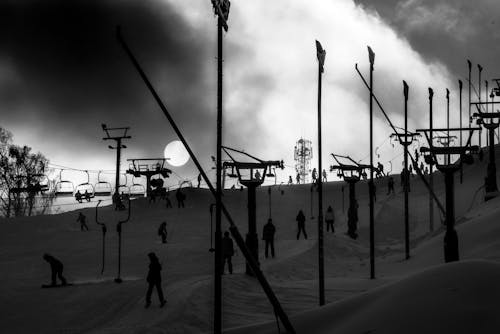 Ski lift silhouettes and sun in the fog