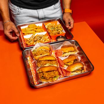 Mouthwatering burgers and fries on trays ready to be enjoyed in a vibrant setting.