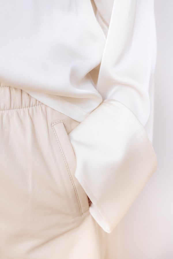 Ivory blouse cuff against cream shorts — Filipp Romanovski on Pexels