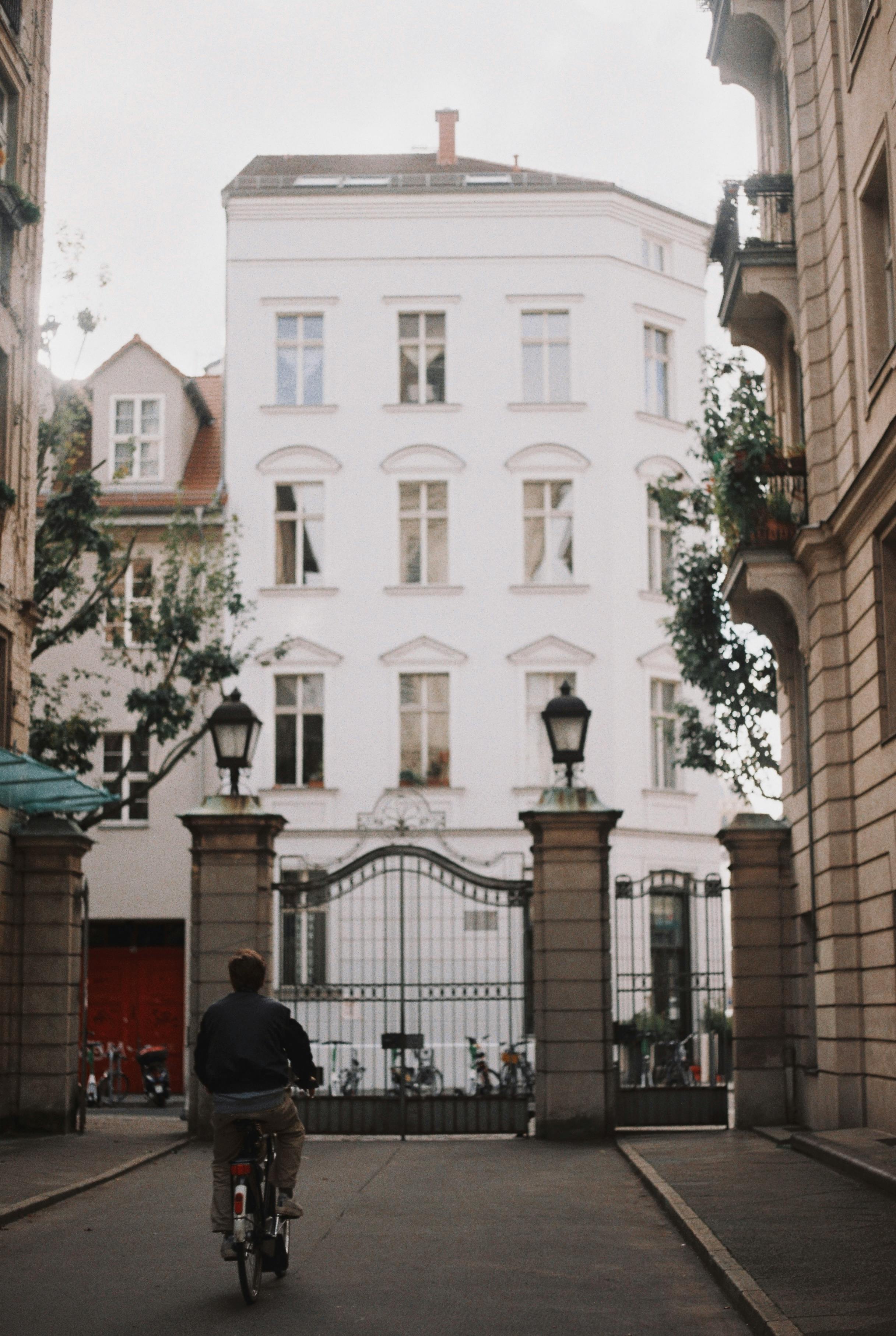 A cyclist rides through a picturesque Berlin street flanked by historic buildings.