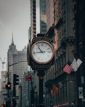 Vintage clock in front of Trump Tower set against New York City's urban skyline.