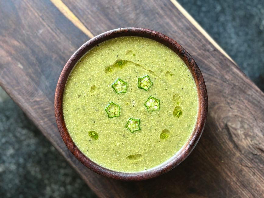 A bowl of ground spice mixture with okra seeds visible throughout`