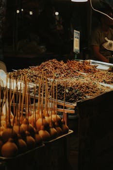 Close-up of a night market display featuring exotic street food skewers.