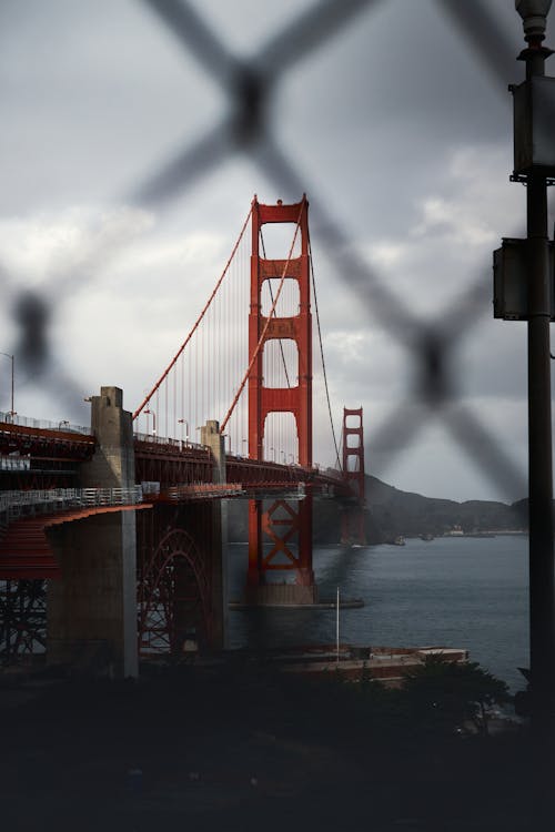 A view of the golden gate bridge through a chain link fence