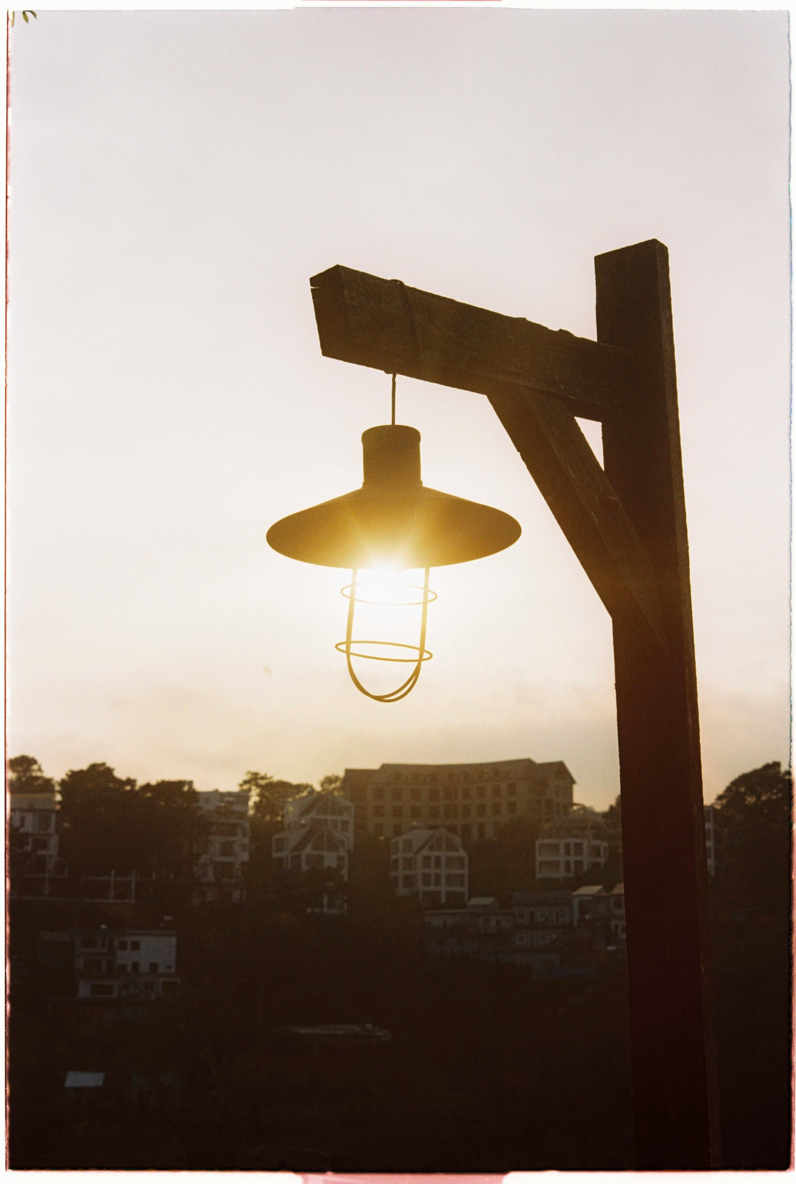 A traditional lamp post silhouetted against a sunset in Dalat, Vietnam.