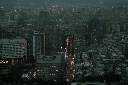 Captivating aerial view of a bustling city with skyscrapers and light traffic at twilight.