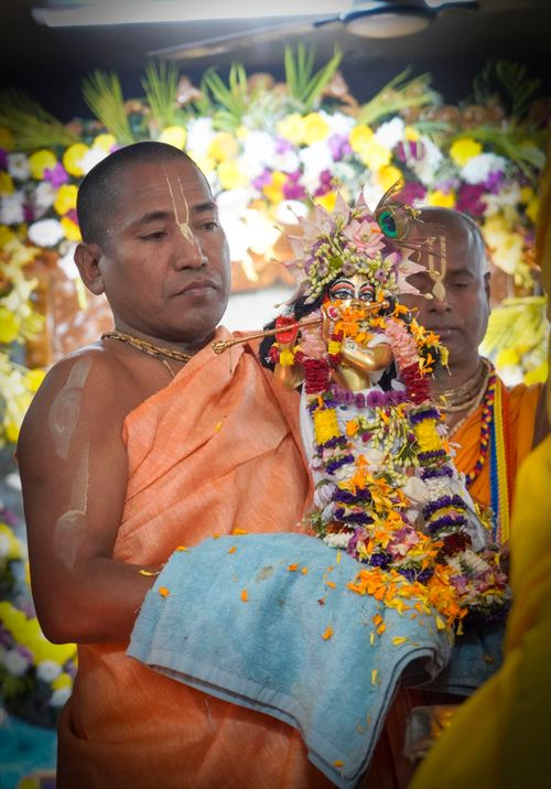 Free Monk holding decorated deity figurine during a traditional Hindu ceremony. Stock Photo