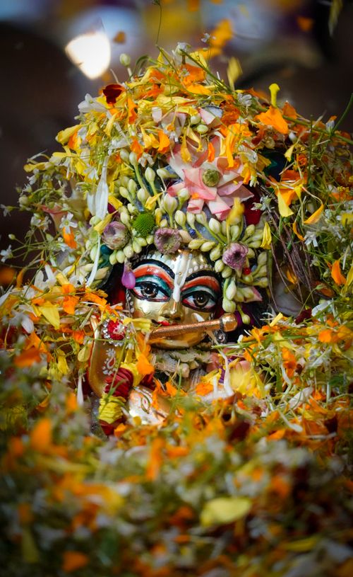 Free Vibrant Hindu deity figurine adorned with colorful flowers, symbolizing spirituality and tradition. Stock Photo