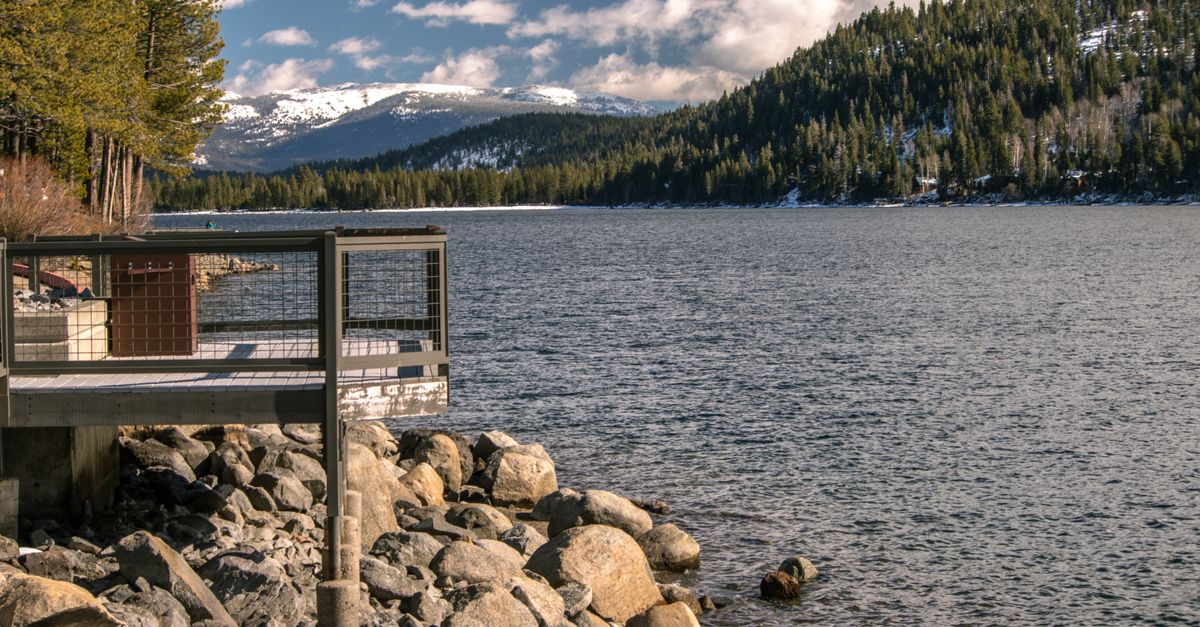 A beautiful winter scene of Donner Lake with snow-capped mountains and tranquil waters in Truckee, California.