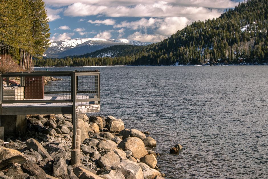 A beautiful winter scene of Donner Lake with snow-capped mountains and tranquil waters in Truckee, California.