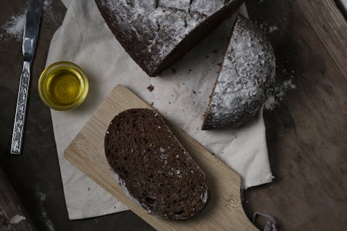 A loaf of bread with a knife and olive oil