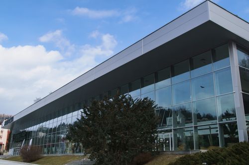 Free Contemporary glass structure reflecting the sky in Krynica-Zdrój, Poland. Stock Photo