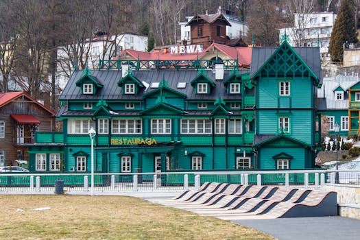 A picturesque green wooden building in Krynica-Zdrój, showcasing traditional architecture with intricate details.