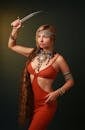 Woman in Red Dress Holding Dagger in Raised Arm