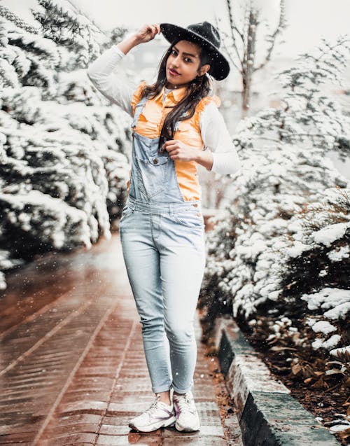 Woman in Hat and Overalls at Park in Winter