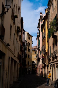 Explore a quaint narrow street in Florence, Italy, capturing the essence of its vibrant city life and architecture.