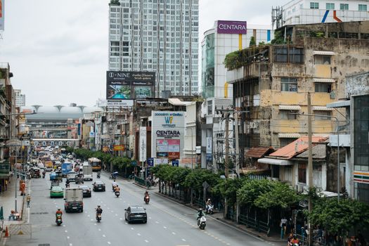 Dynamic street view of Bangkok's bustling cityscape with traffic and modern buildings.
