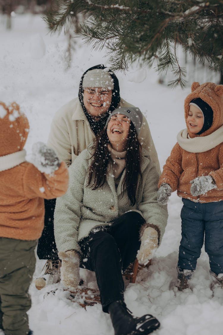 Family With Two Kids Playing In The Snow 