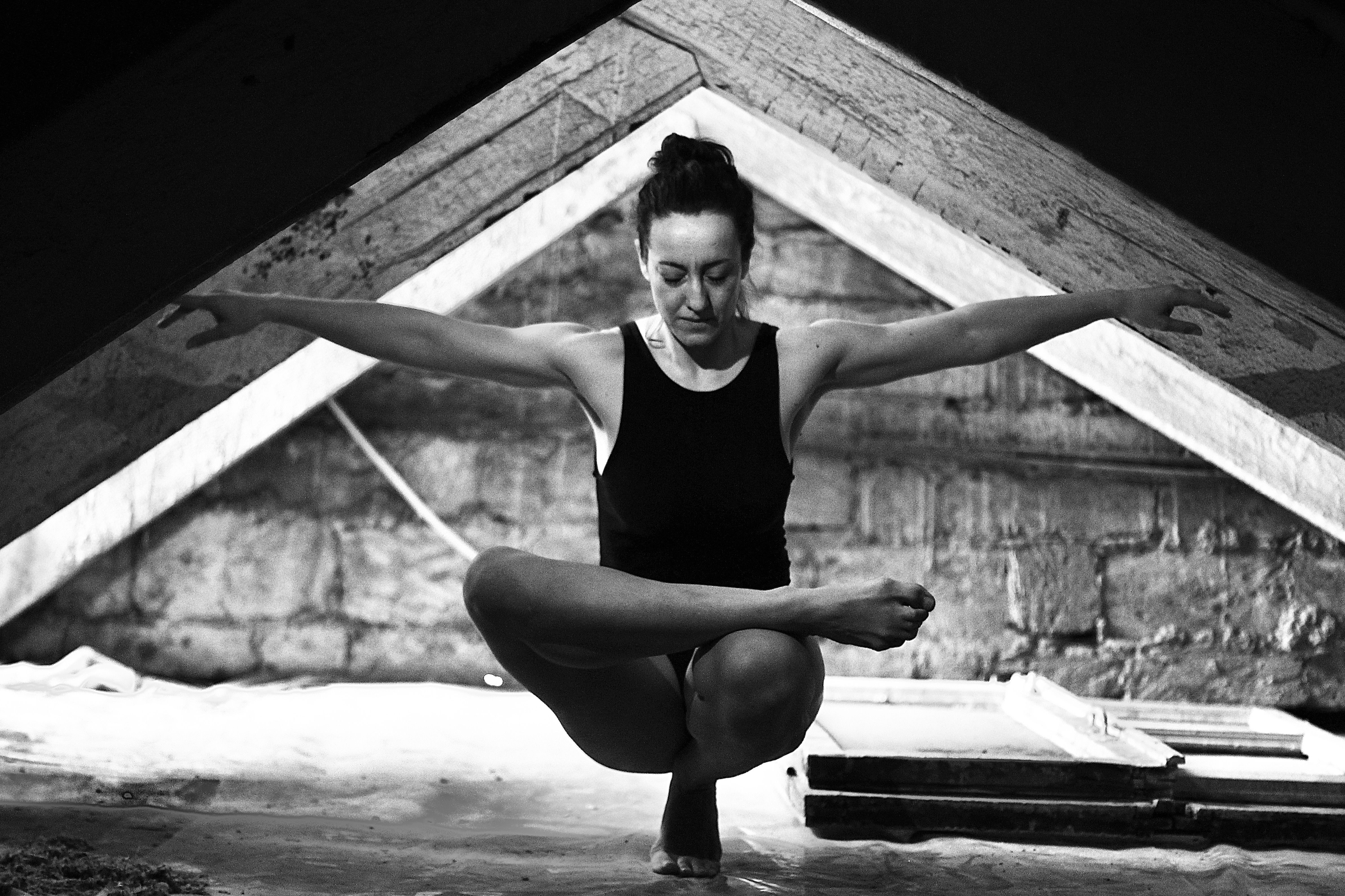 Woman practising yoga in rustic attic setting