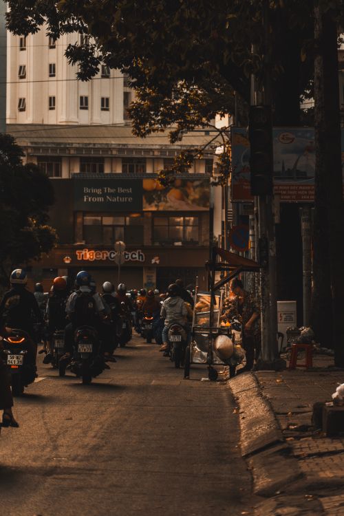 Free Busy street scene in an Asian city with numerous motor scooters navigating traffic. Stock Photo