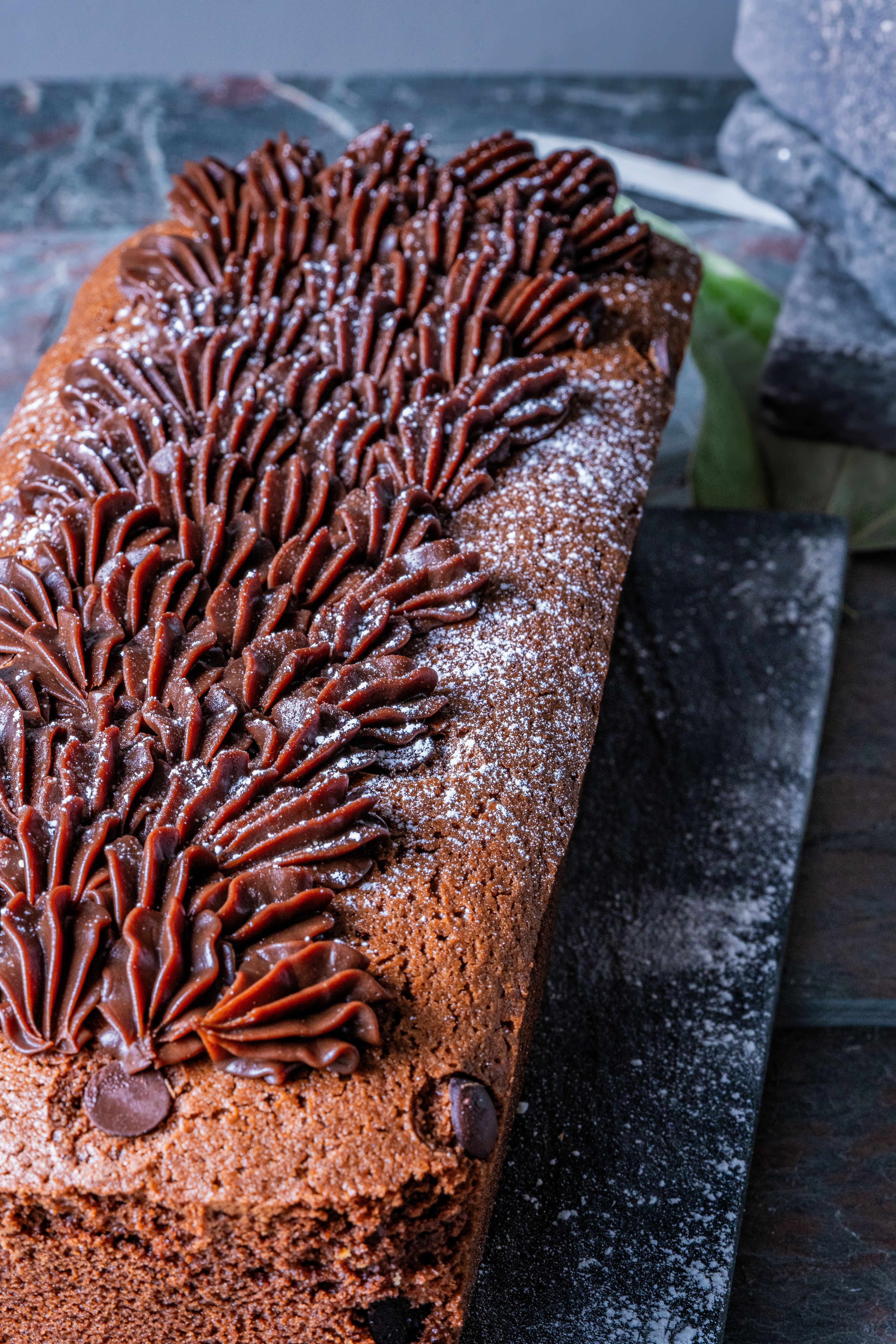 Close-up of a freshly baked chocolate cake with elaborate icing, perfect for dessert lovers.