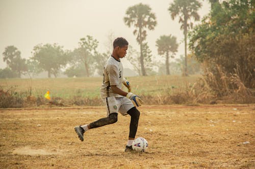 Boy Kicking a Soccer Ball in a Field