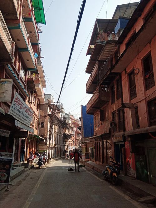 Free Narrow urban alley with people and vibrant buildings, showcasing daily life and architecture. Stock Photo