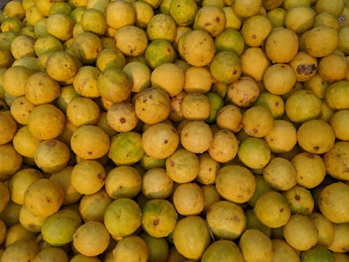 A large pile of yellow fruit sitting on top of each other