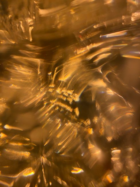 Blurred golden abstract patterns creating a shimmering light effect.