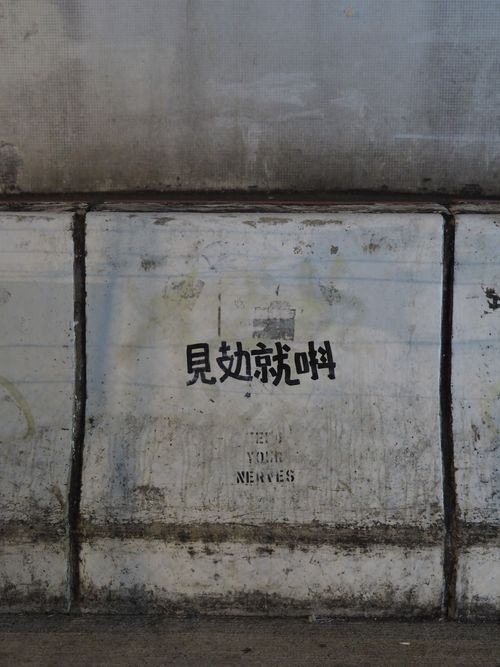 Free Concrete wall with graffiti text in Hong Kong, showcasing urban decay and street art culture. Stock Photo