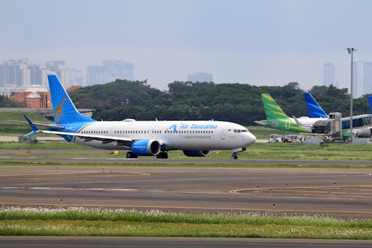 Air Tanzania airplane on tarmac at airport with skyline backdrop. Ideal for aviation and travel imagery.