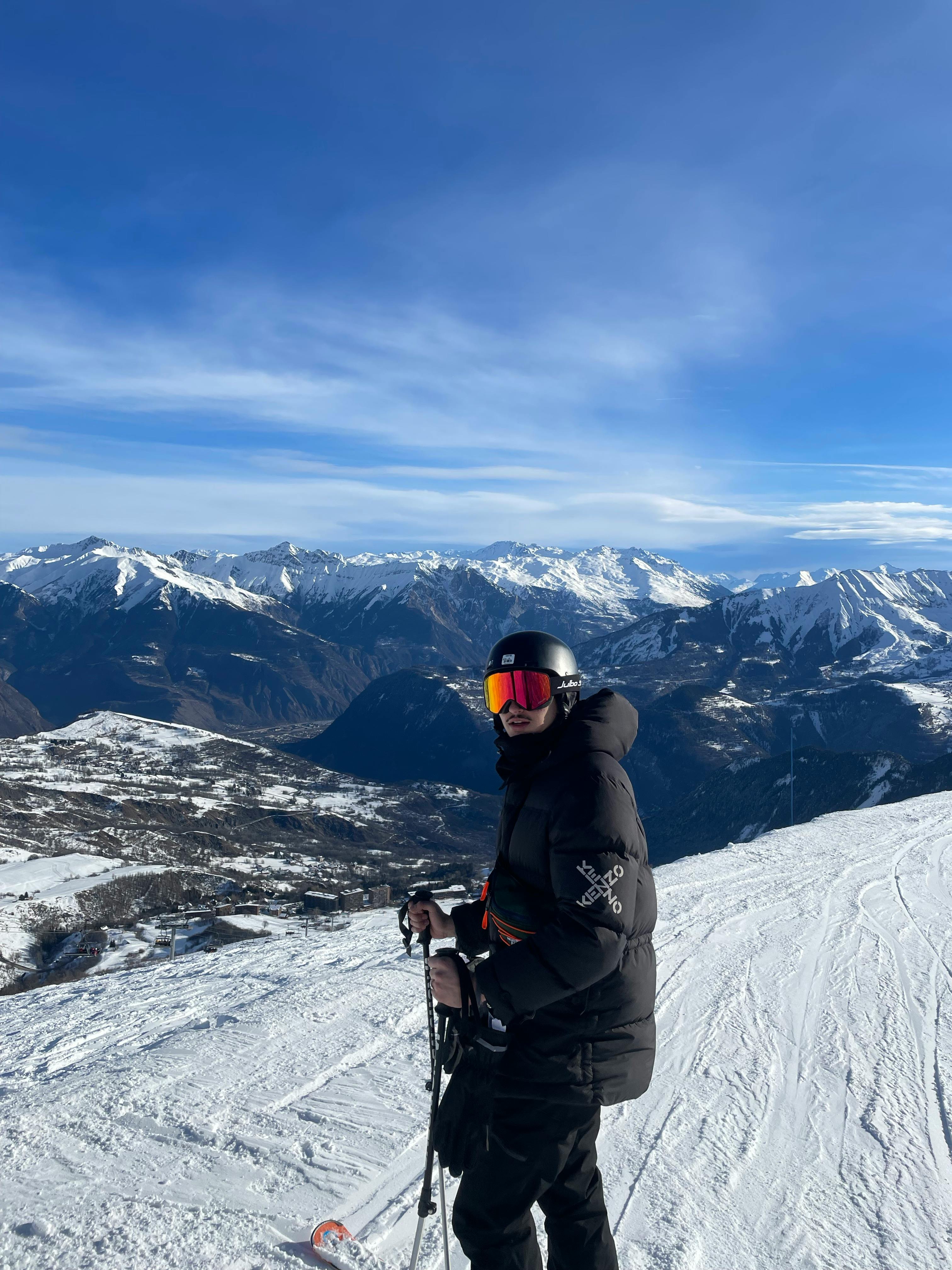 Man skiing in the mountains with a stunning backdrop, enjoying winter sports.